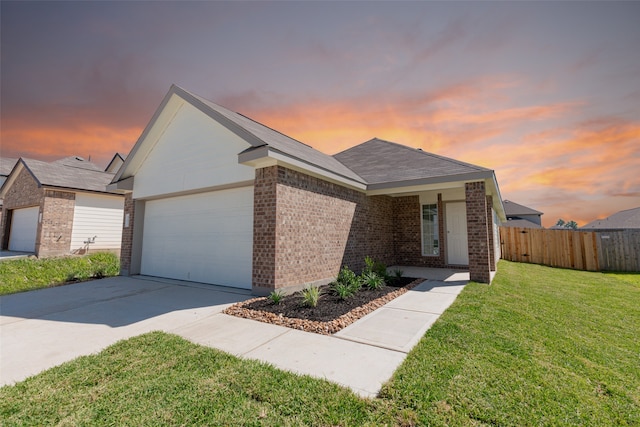 ranch-style house with a garage and a yard