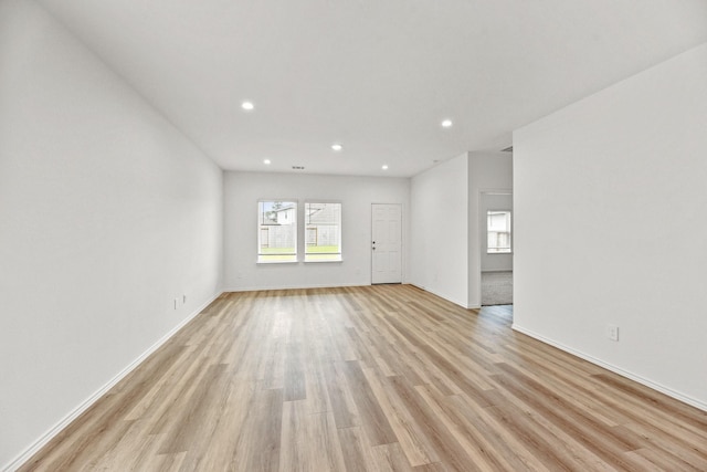 unfurnished living room with baseboards, recessed lighting, and light wood finished floors