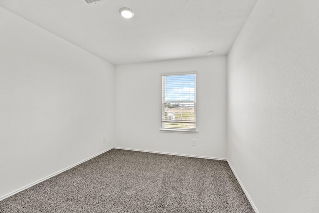 carpeted empty room featuring baseboards