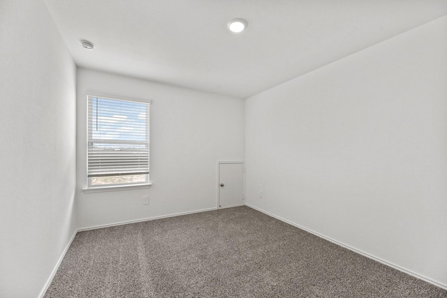 carpeted empty room featuring baseboards