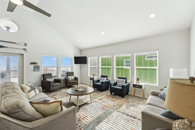 living room with ceiling fan, a healthy amount of sunlight, high vaulted ceiling, and light hardwood / wood-style flooring