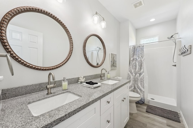 bathroom featuring vanity, toilet, a shower with shower curtain, and hardwood / wood-style flooring