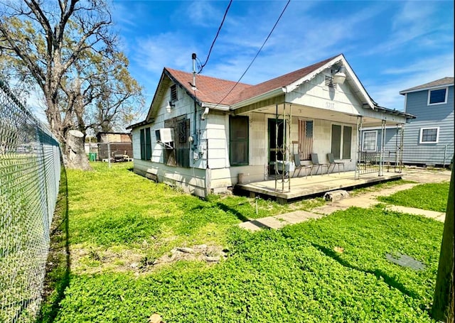 rear view of property featuring a deck and a yard