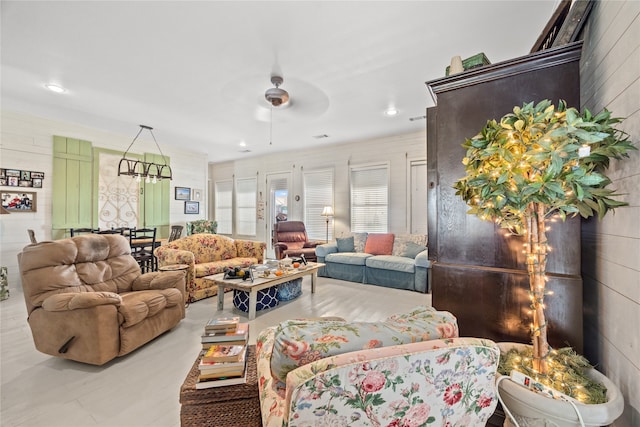 living room featuring ceiling fan and wooden walls