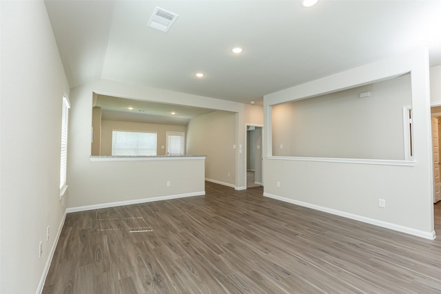 unfurnished room with dark wood-type flooring and lofted ceiling