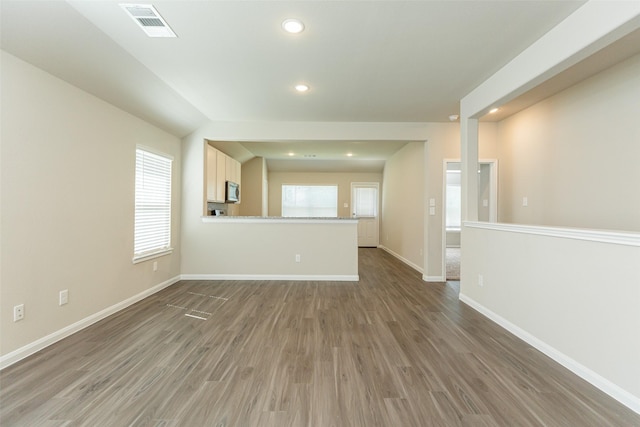 unfurnished living room featuring dark hardwood / wood-style floors and a healthy amount of sunlight