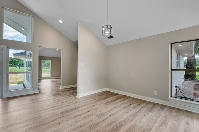 empty room featuring light hardwood / wood-style flooring and high vaulted ceiling