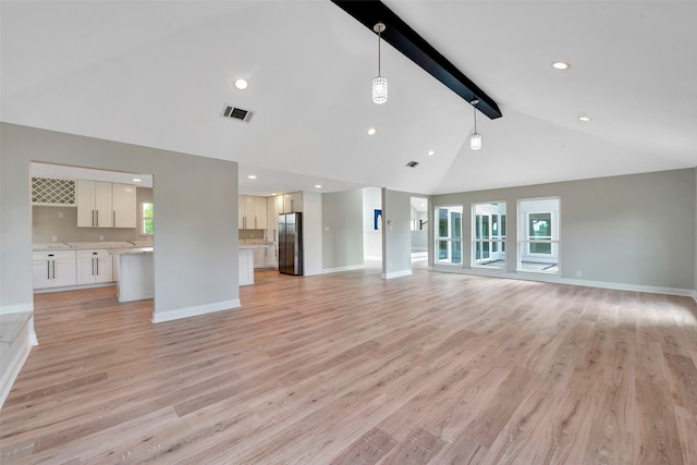 unfurnished living room featuring beamed ceiling, light hardwood / wood-style flooring, and high vaulted ceiling