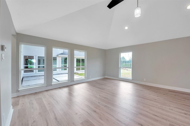 empty room with light hardwood / wood-style floors and high vaulted ceiling