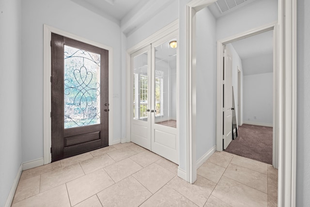 tiled foyer entrance with french doors and a wealth of natural light