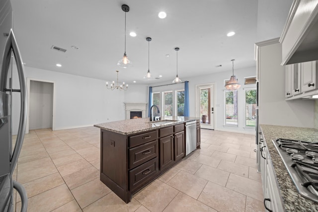 kitchen featuring appliances with stainless steel finishes, dark brown cabinetry, sink, decorative light fixtures, and white cabinets