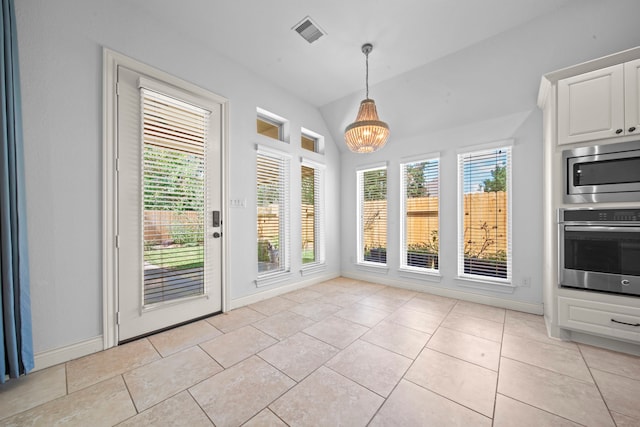 interior space featuring light tile patterned floors, vaulted ceiling, and a notable chandelier