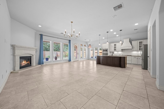 kitchen with pendant lighting, a center island with sink, stainless steel appliances, and plenty of natural light