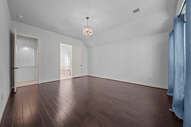 unfurnished bedroom with a chandelier, dark hardwood / wood-style flooring, and vaulted ceiling