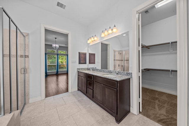 bathroom with a chandelier, wood-type flooring, vanity, and walk in shower