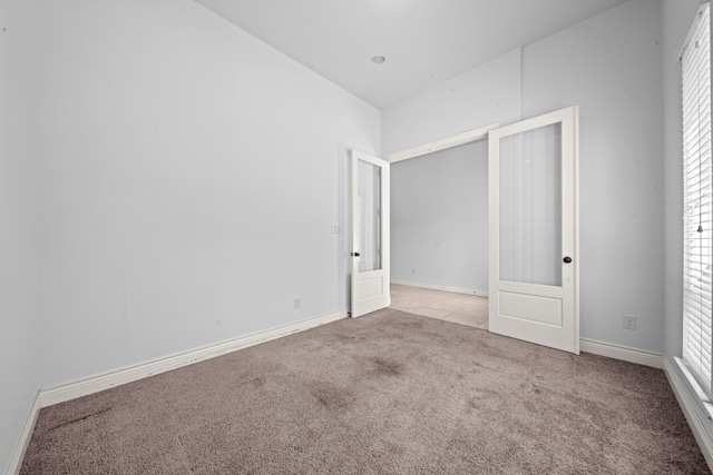 unfurnished bedroom with french doors and light colored carpet