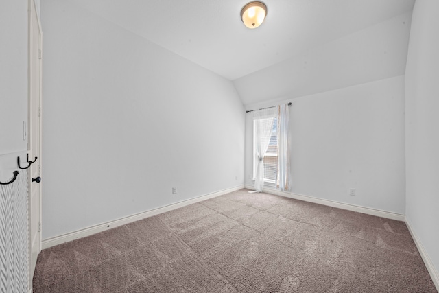 interior space with light carpet and vaulted ceiling