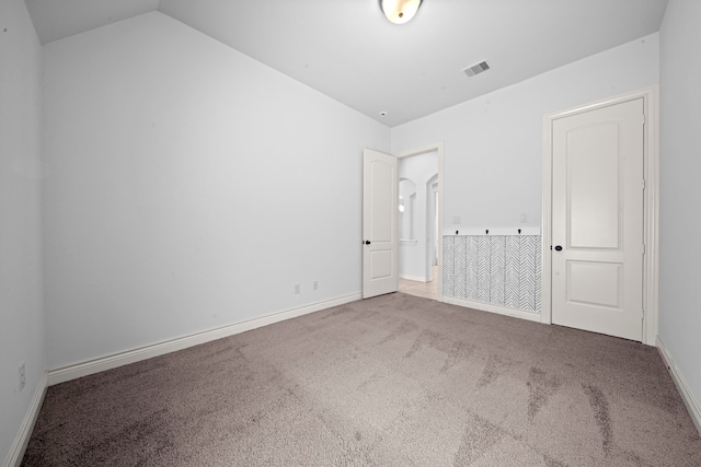 unfurnished bedroom with carpet and vaulted ceiling