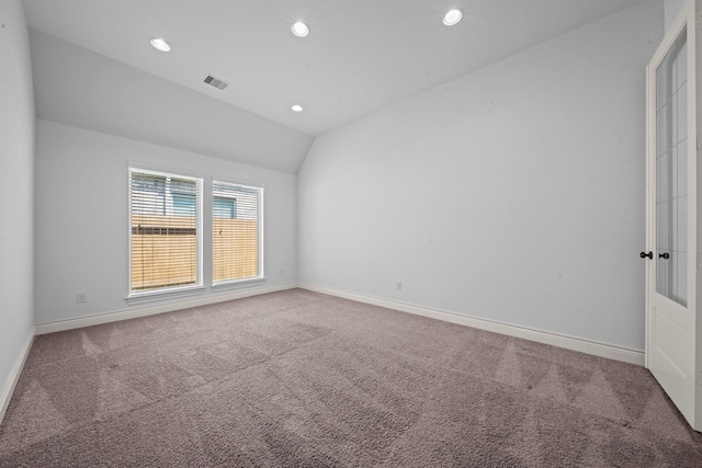 unfurnished room with carpet floors and lofted ceiling