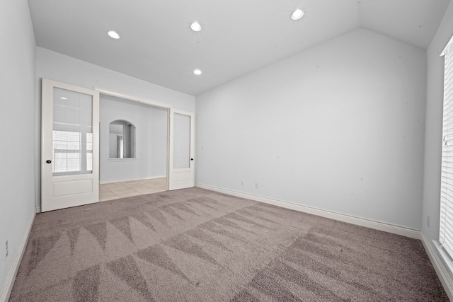 unfurnished bedroom with light colored carpet and vaulted ceiling