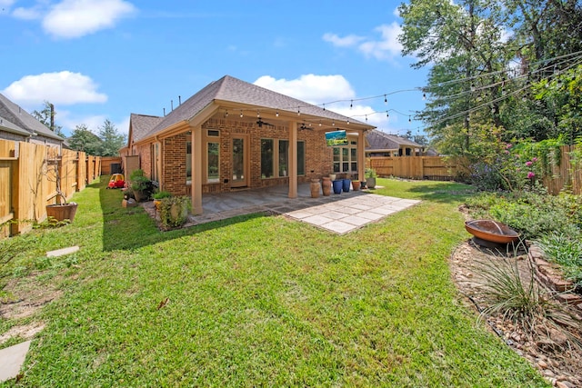 rear view of house with a lawn, ceiling fan, a patio, and a fire pit