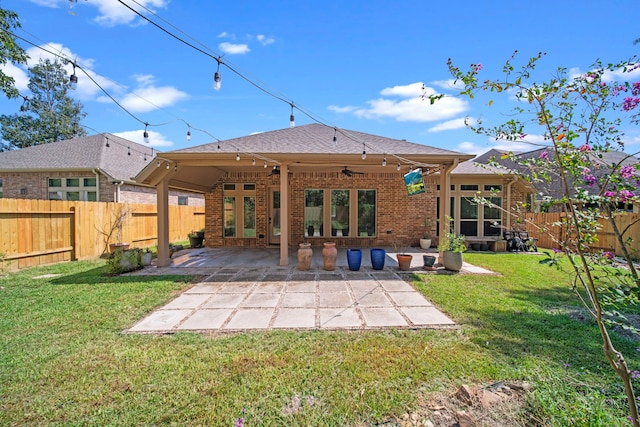 rear view of property featuring a lawn, ceiling fan, and a patio area