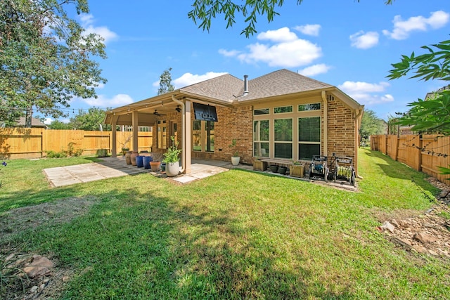 rear view of house featuring a patio area and a yard