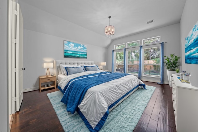 bedroom with a chandelier, dark wood-type flooring, and lofted ceiling