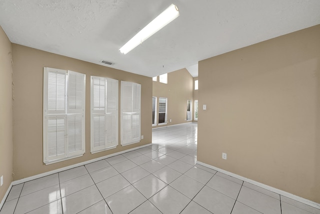 unfurnished room featuring a textured ceiling and light tile patterned floors