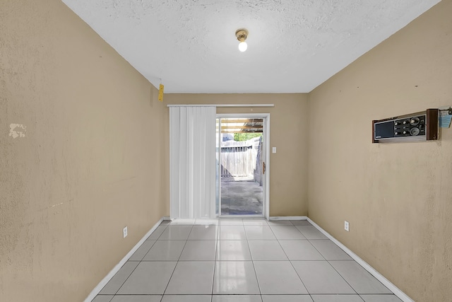 tiled spare room with a textured ceiling