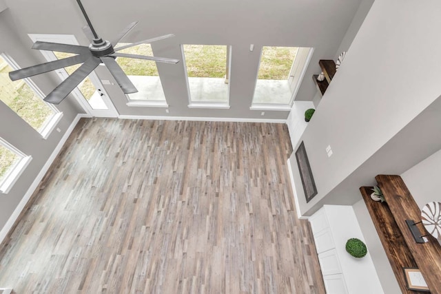 unfurnished living room featuring ceiling fan and hardwood / wood-style floors