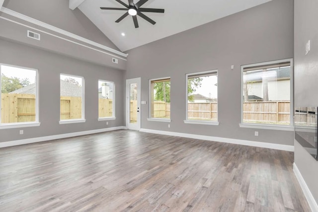 unfurnished living room with high vaulted ceiling, wood-type flooring, and ceiling fan