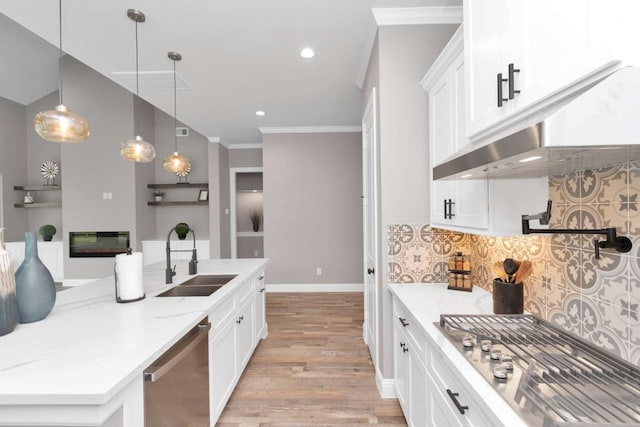 kitchen featuring appliances with stainless steel finishes, light stone counters, white cabinets, light wood-type flooring, and sink