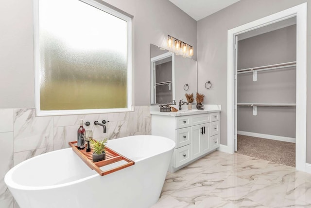 bathroom with vanity, a bathing tub, and tile walls