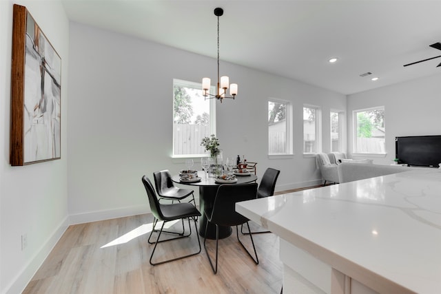 dining room with light hardwood / wood-style flooring and an inviting chandelier