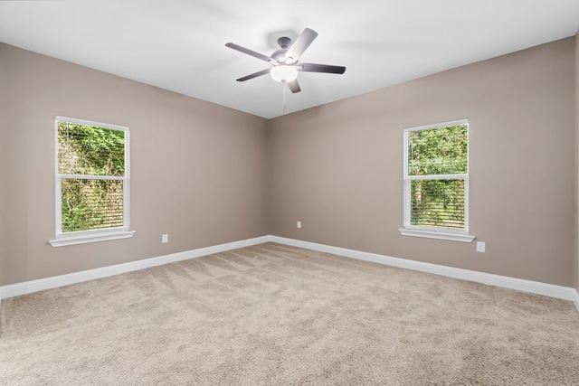 carpeted empty room with ceiling fan and a healthy amount of sunlight