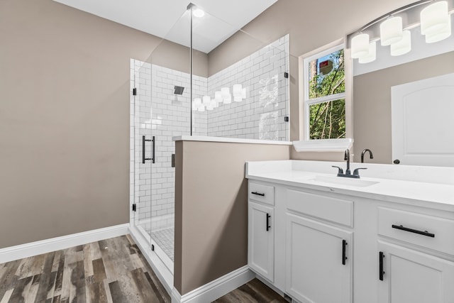 bathroom with walk in shower, vanity, and hardwood / wood-style flooring