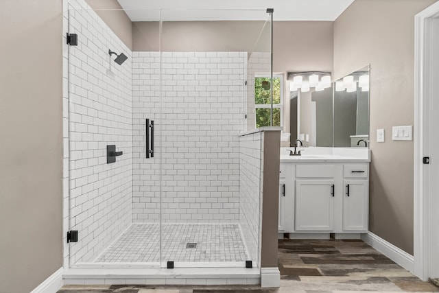 bathroom with wood-type flooring, a shower with door, and vanity