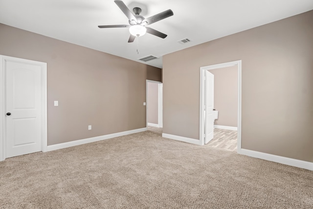 unfurnished bedroom featuring ceiling fan, light colored carpet, and ensuite bathroom