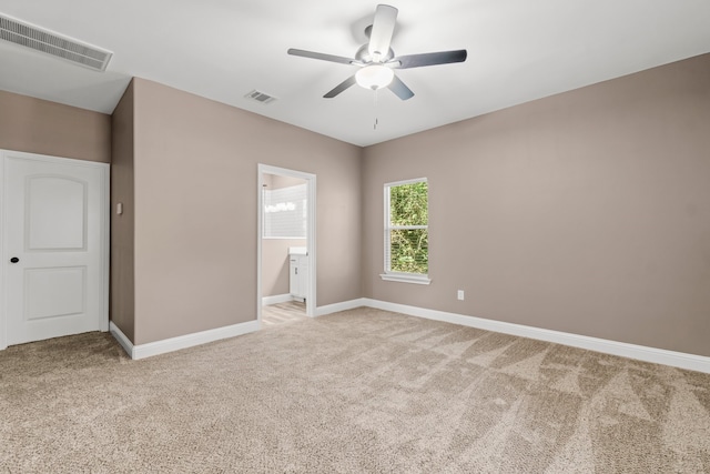 unfurnished bedroom with light carpet, ceiling fan, and ensuite bathroom