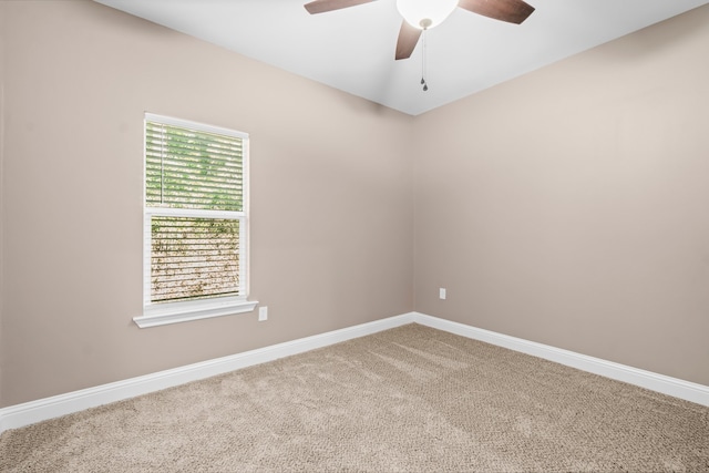 carpeted spare room featuring ceiling fan