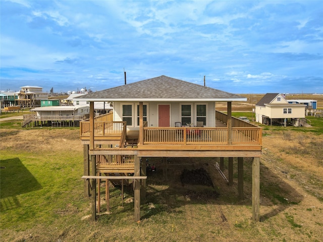 rear view of property featuring a deck and a lawn