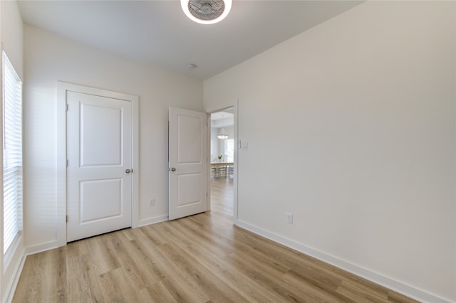 unfurnished bedroom featuring light wood-type flooring and multiple windows