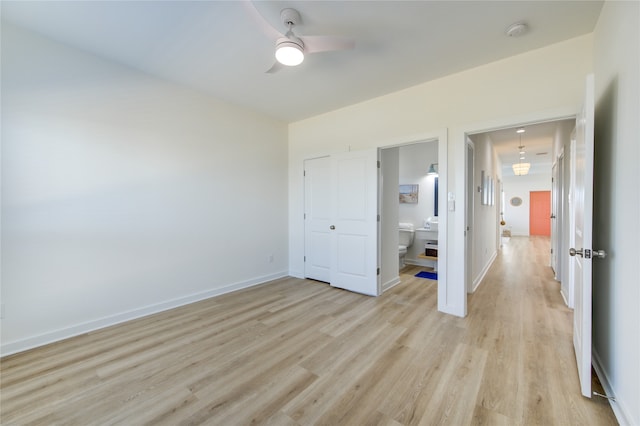 unfurnished bedroom with ceiling fan, a closet, connected bathroom, and light hardwood / wood-style floors