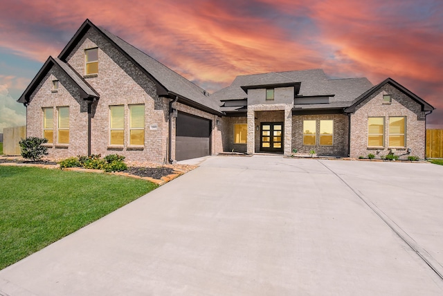 view of front of home with a yard and a garage