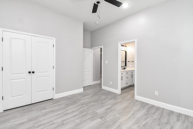 unfurnished bedroom with ceiling fan, light wood-type flooring, a closet, and ensuite bath