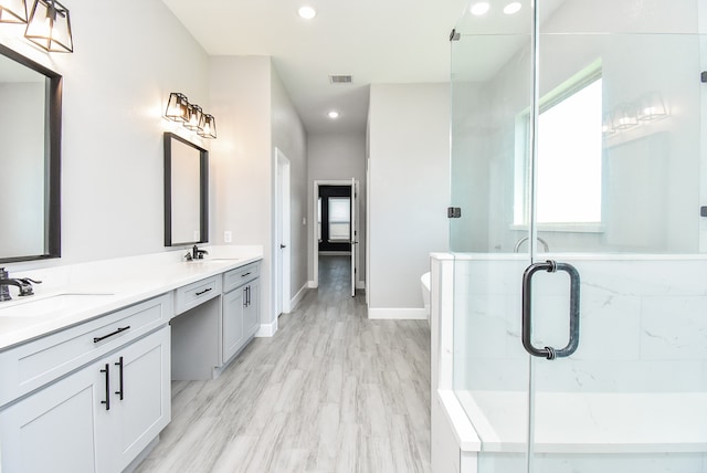 bathroom featuring vanity, hardwood / wood-style flooring, and a shower with shower door