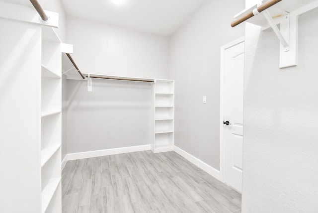 walk in closet with light hardwood / wood-style floors