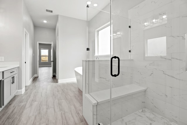 bathroom featuring vanity, plus walk in shower, hardwood / wood-style flooring, and a healthy amount of sunlight