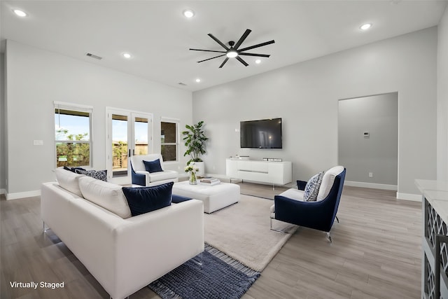 living room featuring french doors, light hardwood / wood-style floors, and ceiling fan